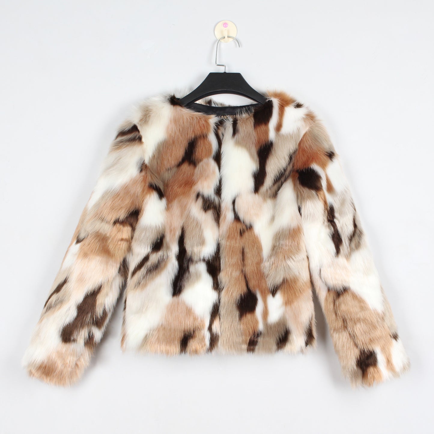Faux fur coat with a pattern on a hanger against a white background