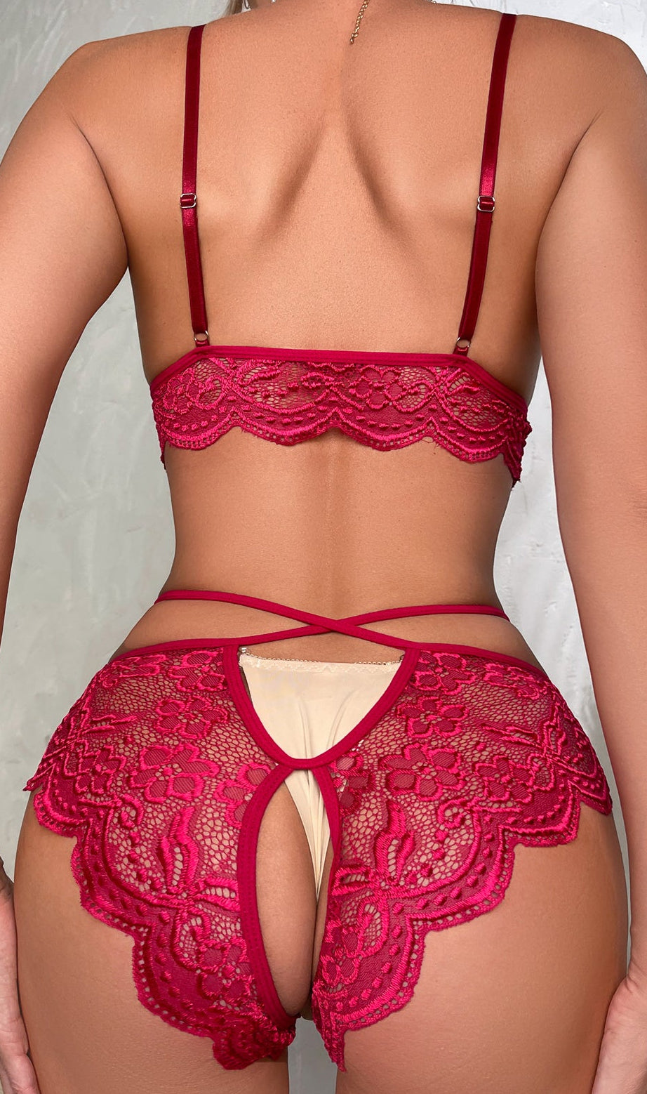 Red lace lingerie set worn by a model against a neutral background