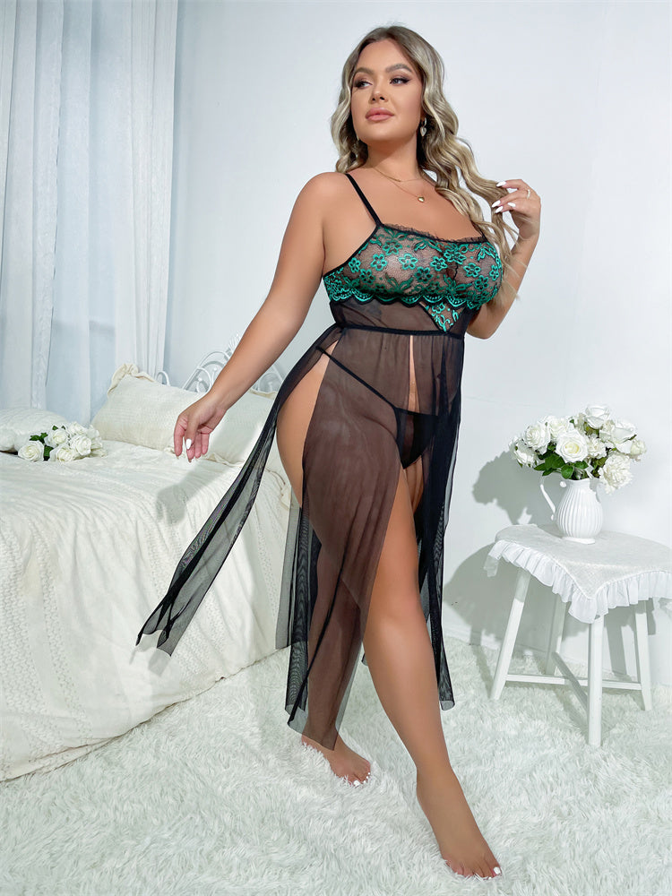 Woman wearing a green lace lingerie set with sheer black skirt in a bedroom setting.