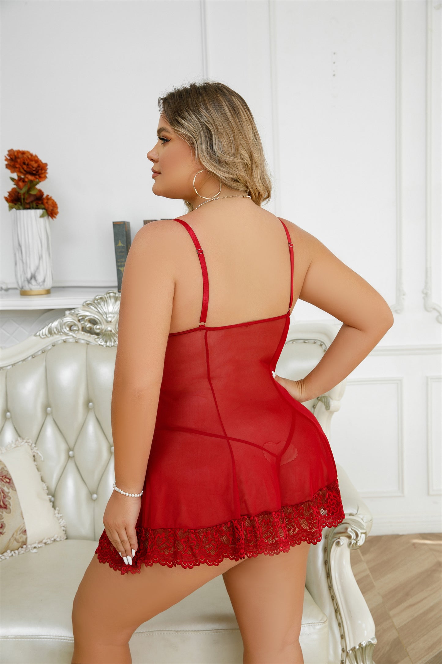 Woman wearing a red lace nightgown in a elegant room.
