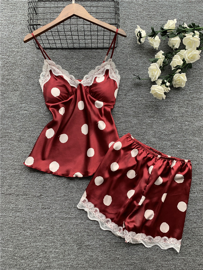 Red satin nightgown with white polka dots and lace trim on a gray background.