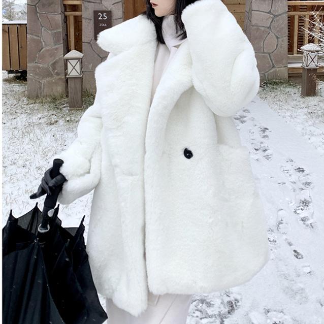 Person wearing a white fur coat in a snowy outdoor setting