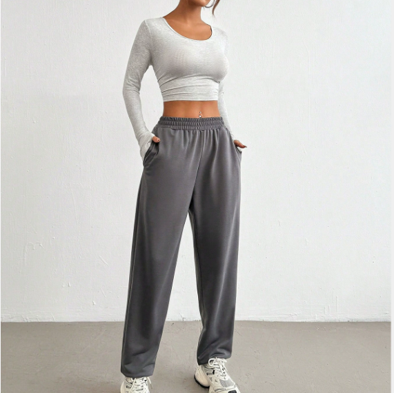 Person wearing a gray long-sleeve crop top and gray sweatpants on a white background