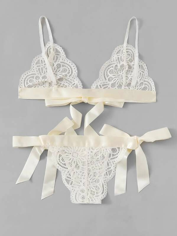 Lace bra and panties set with satin ribbons on a gray background