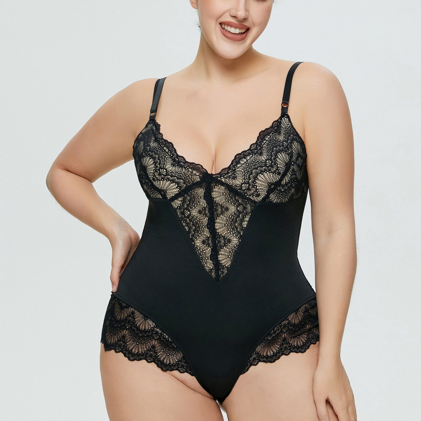 Curvy model posing in black lace plus size bodysuit