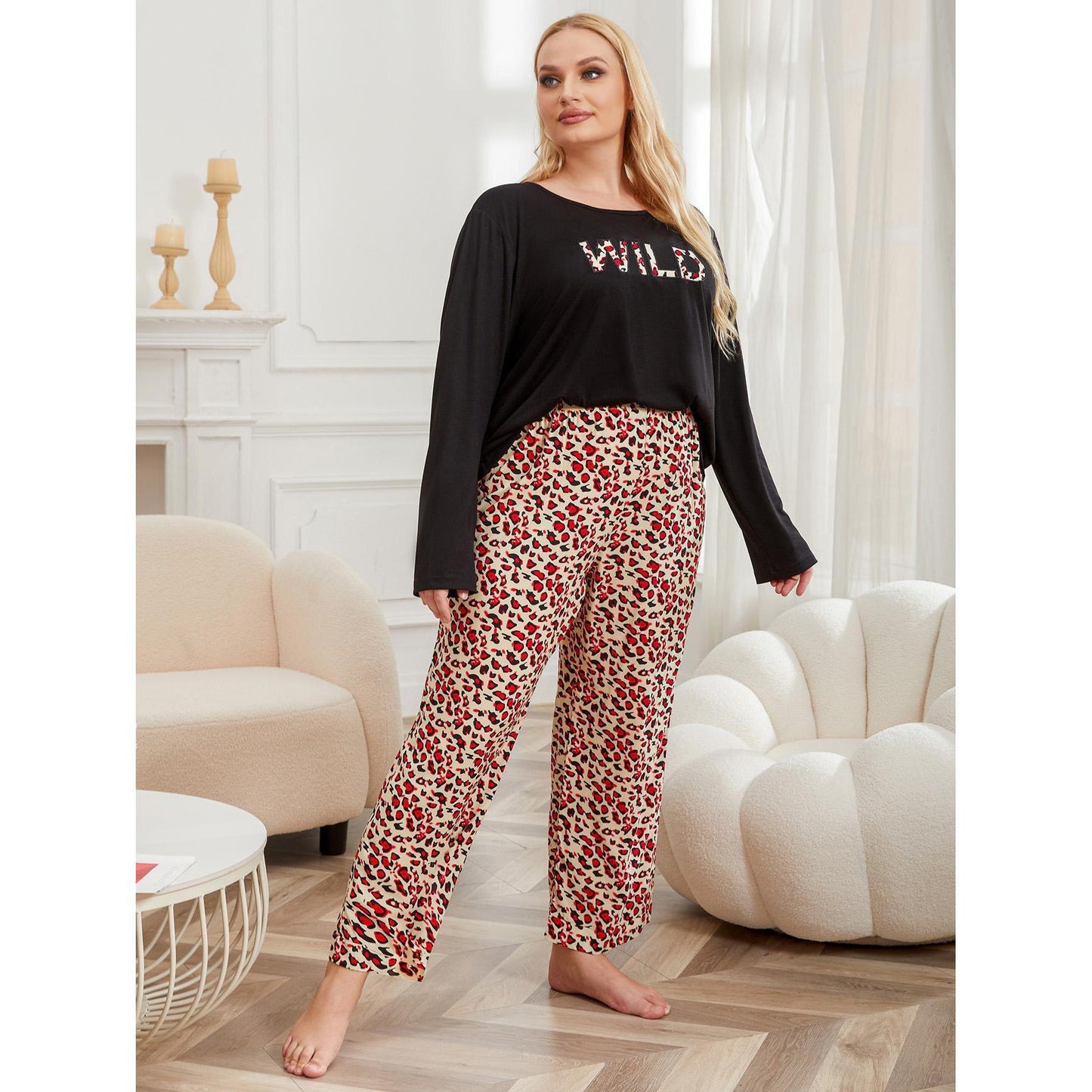 Woman wearing a black top with 'WILD' text and patterned pants in a living room.