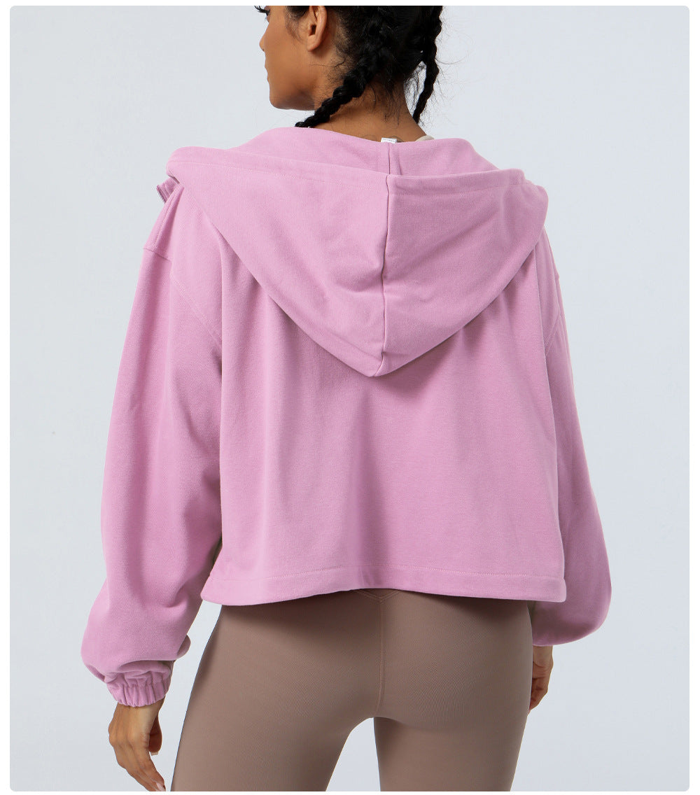 Person wearing a pink hoodie from behind on a light gray background
