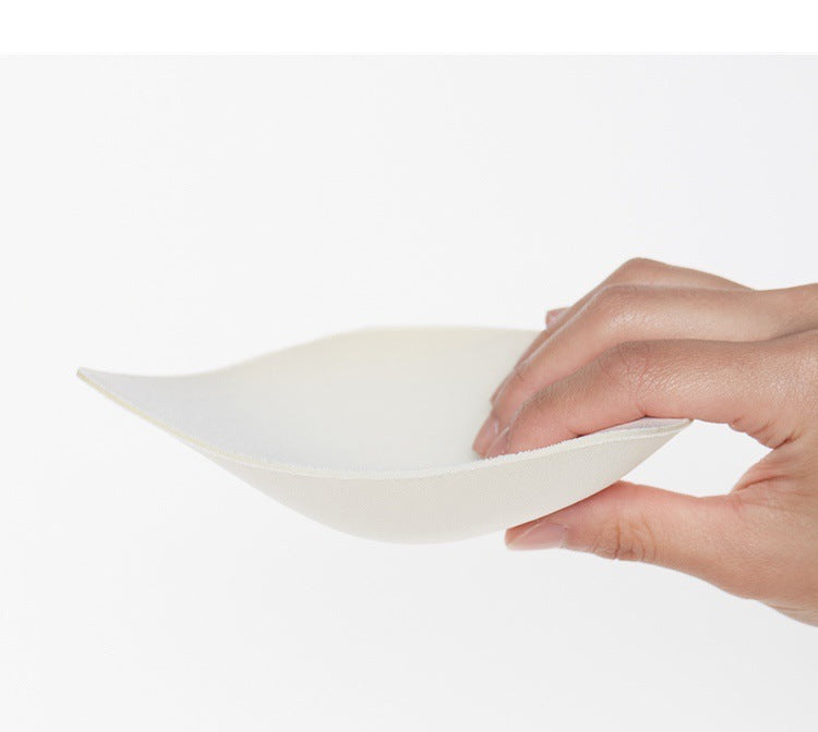 Hand holding a white bra support on a white background