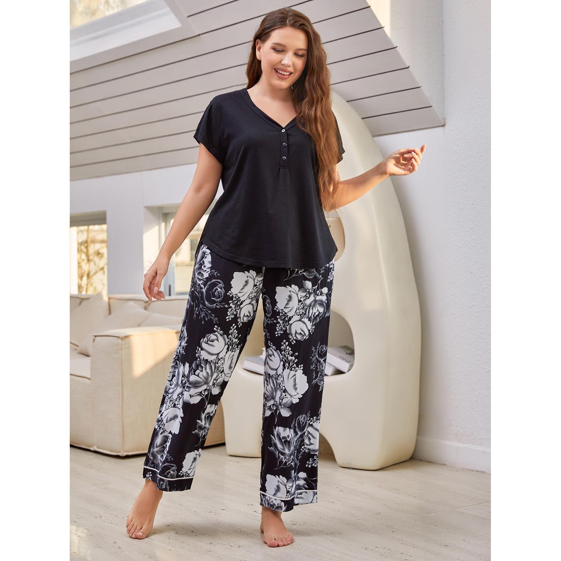 Woman wearing a black top and floral pants in a modern living room.