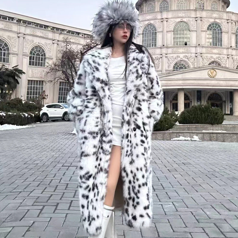 Person wearing a long fur coat with a snowflake pattern in front of a large building.