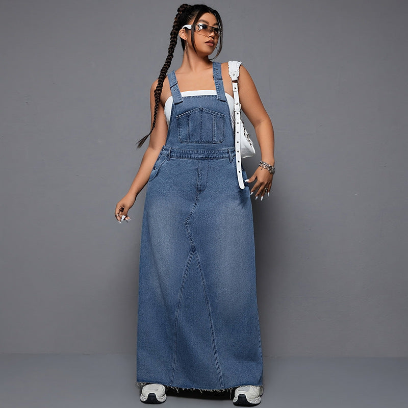 Woman wearing a long denim dress against a gray background