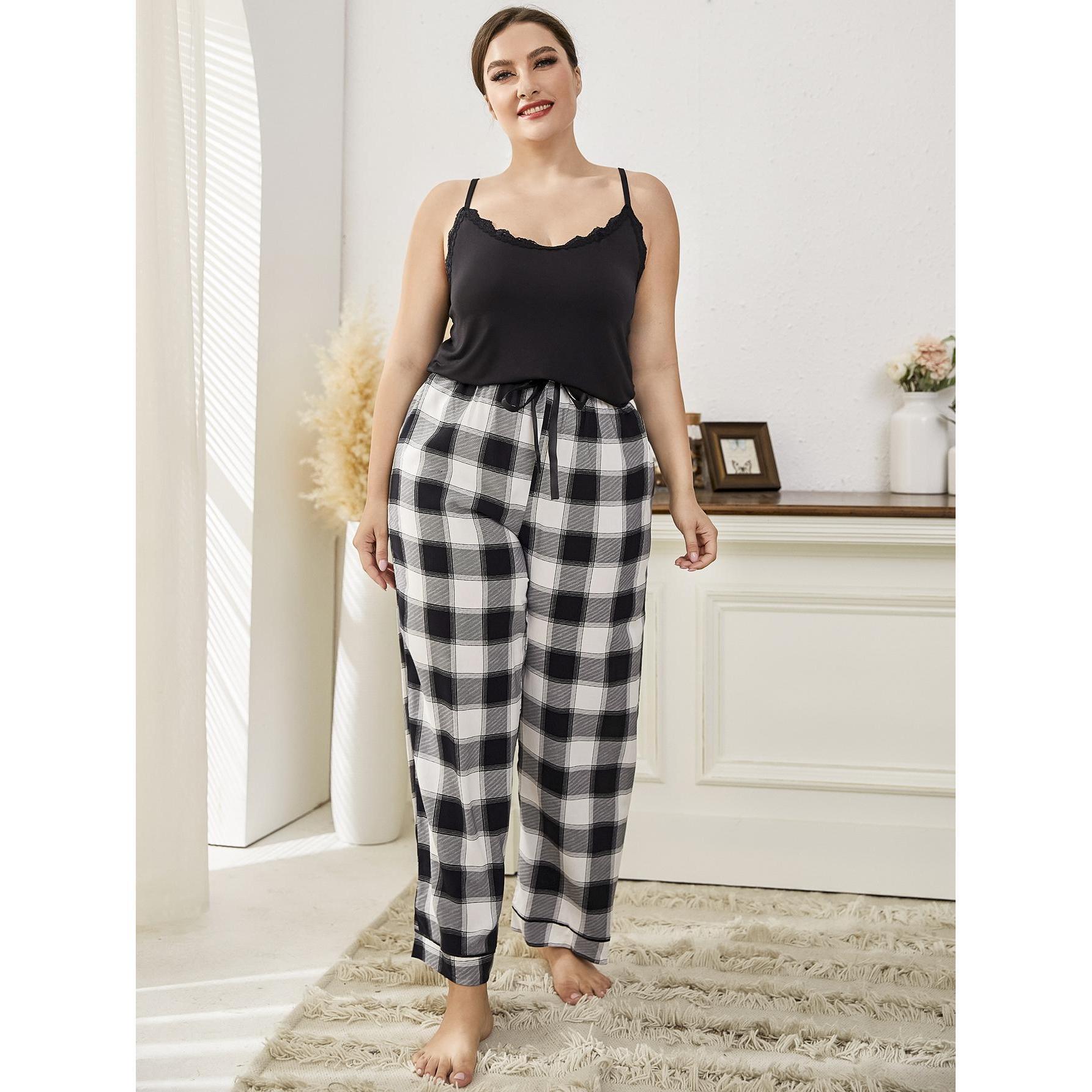 Woman wearing a black top and plaid pants in a bright room.