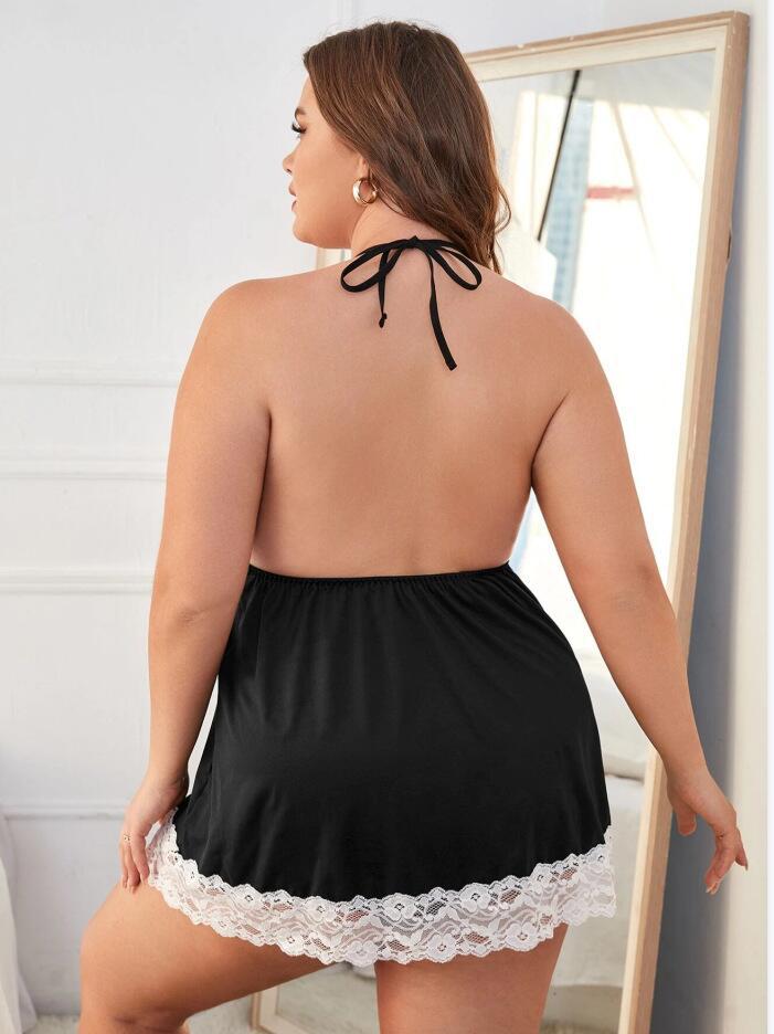 Woman wearing a black satin nightgown with lace hem in a room.