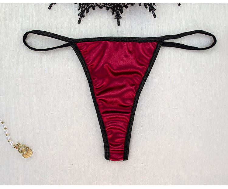 Red thong with black straps on a white background