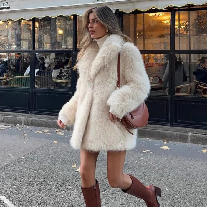Woman wearing a fluffy white coat and brown boots walking on a street.