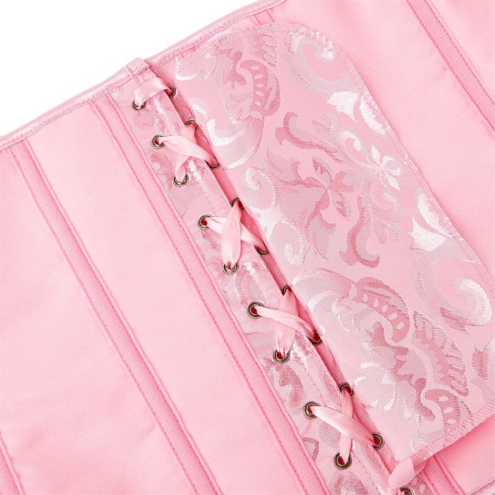 Pink notebook with lace detailing on a white background