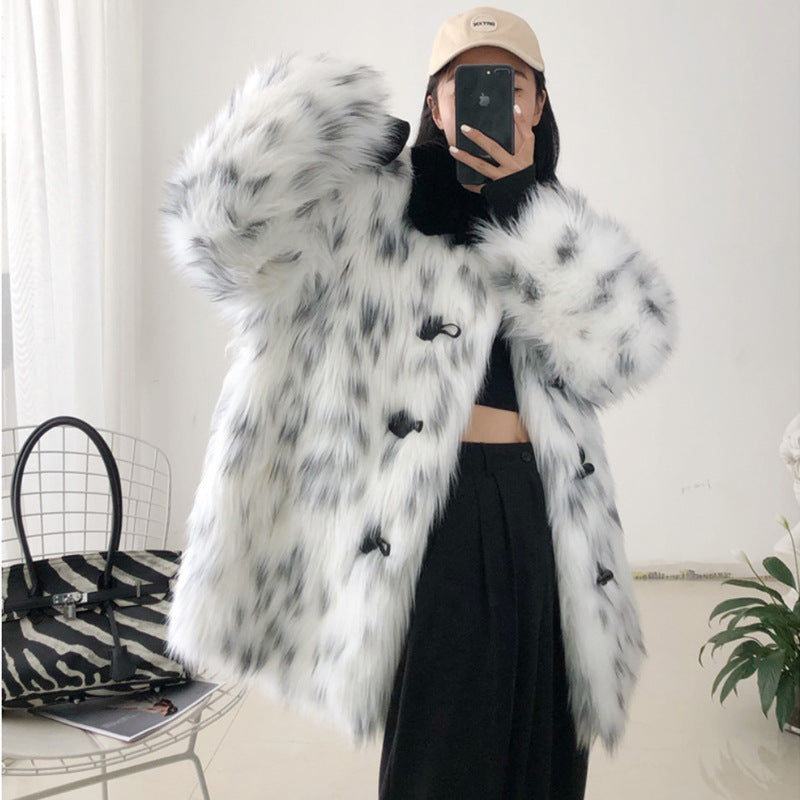 Person wearing a black and white fur coat taking a mirror selfie.