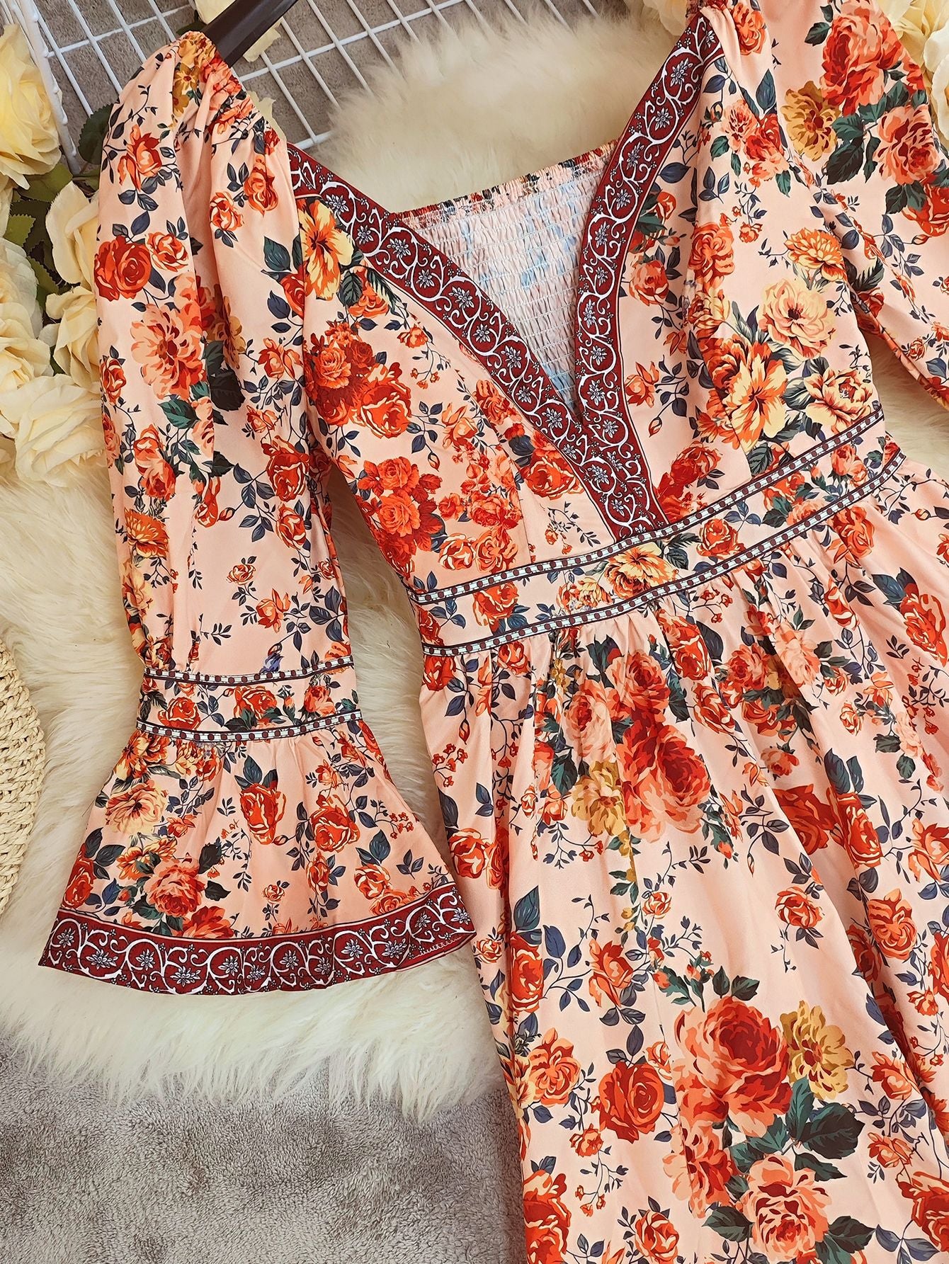 Floral dress with orange and red flowers on a textured surface