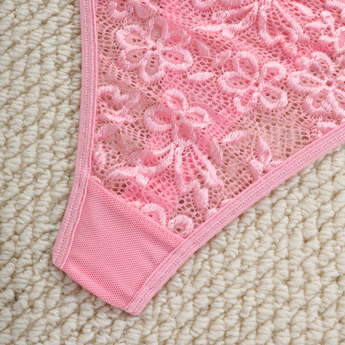 Close-up of a pink lace doily on a beige surface