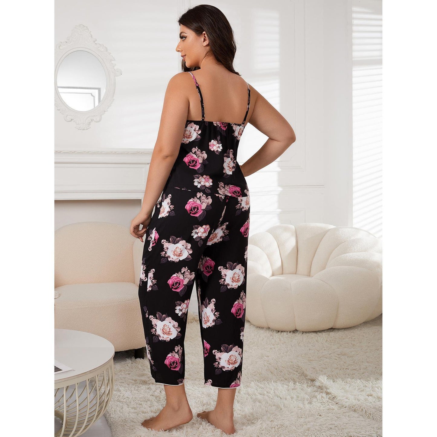 Woman wearing a black floral jumpsuit in a living room setting