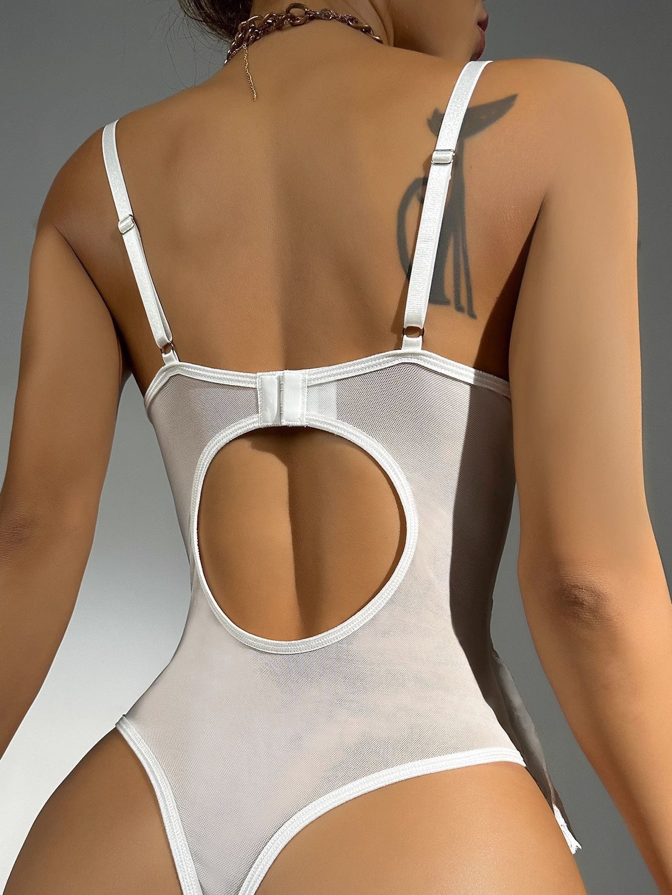 White swimsuit with cut-out design on a neutral background