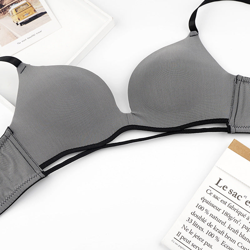 Gray bra with black straps on a white surface