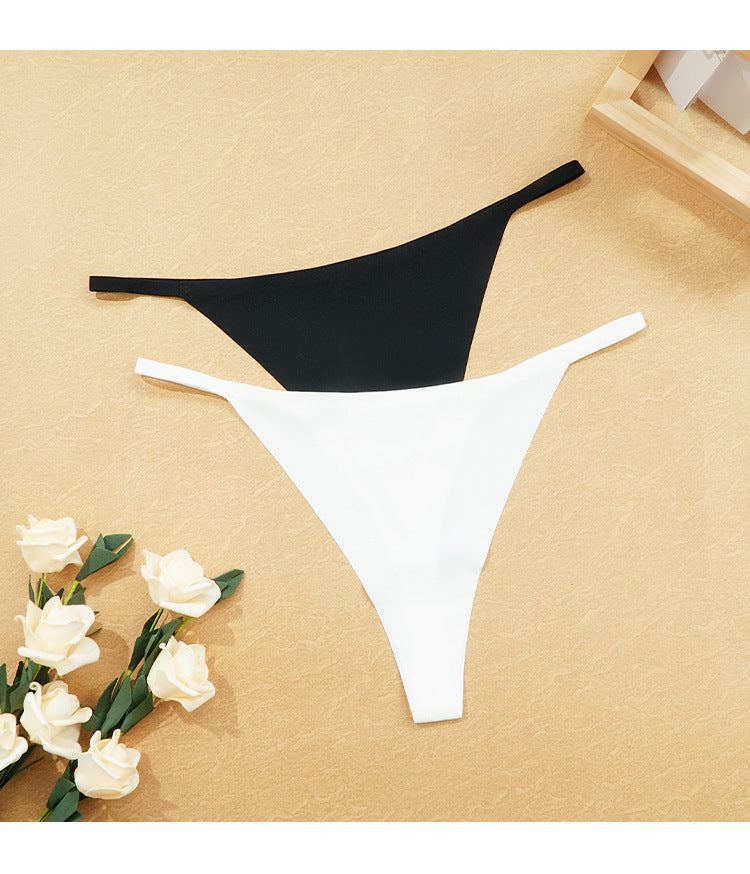 Black and white bikini bottoms on a beige surface with flowers.
