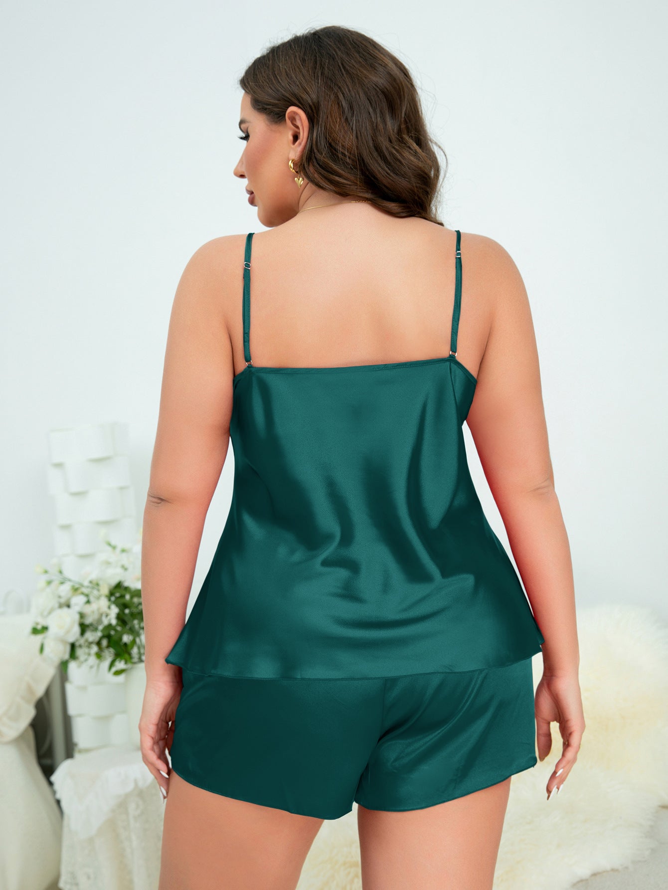 Woman wearing a green satin nightgown with a white background