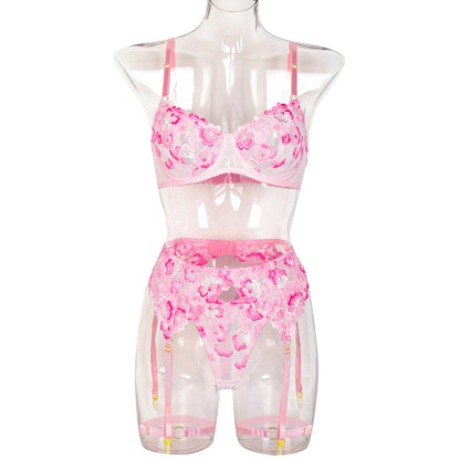 “Close-up of heavy floral embroidery and sheer fabric on erotic three-piece lingerie set”