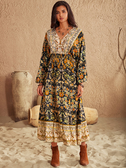 Woman wearing a long, patterned dress with long sleeves in a desert-like setting.