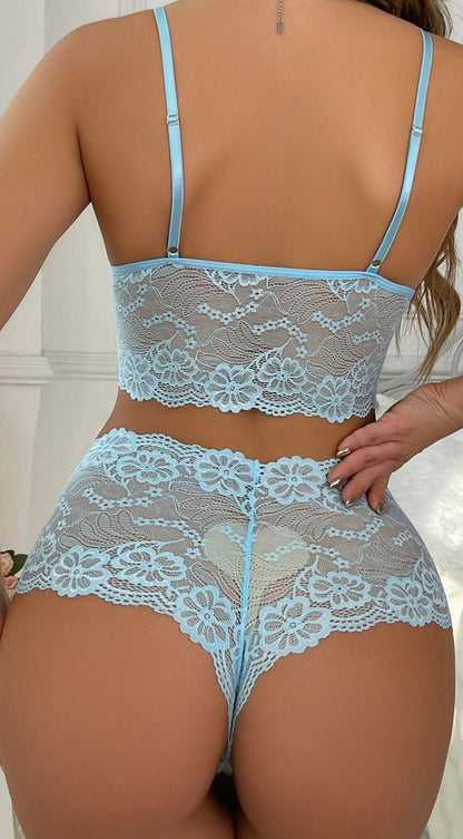 Woman wearing light blue lace lingerie in a bedroom setting