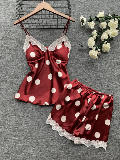 Red satin nightgown with white polka dots and lace trim on a gray background.