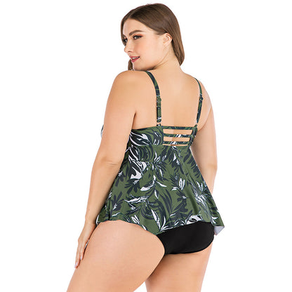 Woman wearing a green leaf-patterned tankini top with black bottoms on a white background