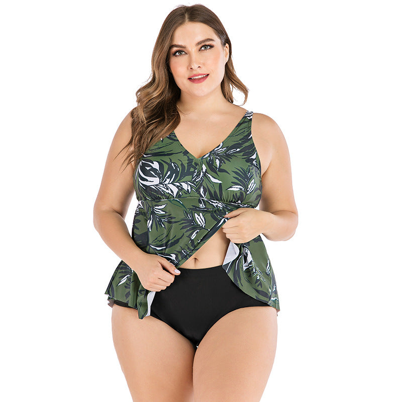 Woman wearing a green leaf-patterned tankini top and black bottom on a white background
