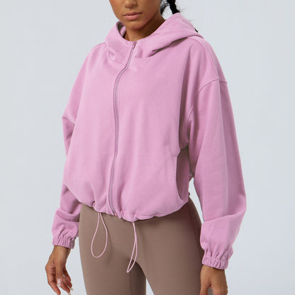 Person wearing a pink hoodie on a light gray background
