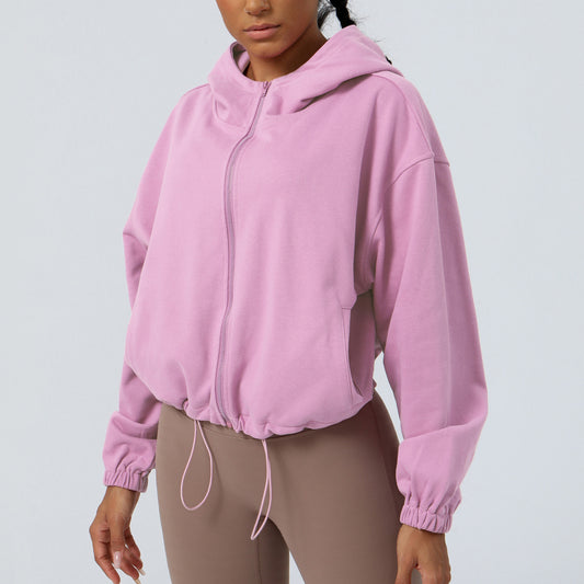 Person wearing a pink hoodie on a light gray background