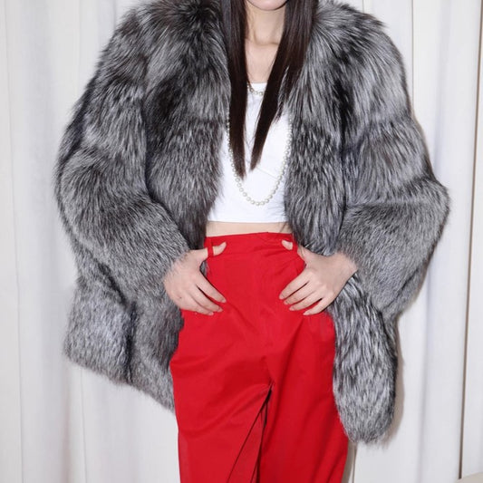Person wearing a gray fur coat and red pants against a white background