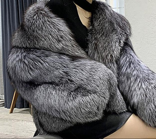 Person wearing a gray fur coat indoors