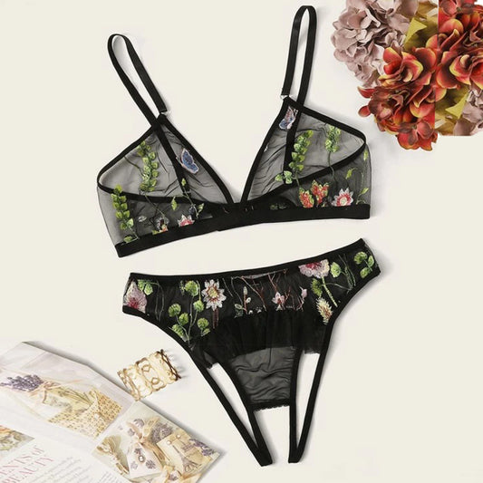 Black floral lingerie set on a light background with decorative elements.