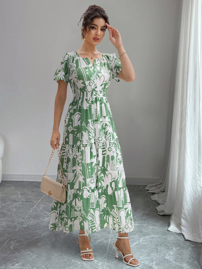 Woman wearing a green and white patterned dress in a room with gray floor and white curtains.