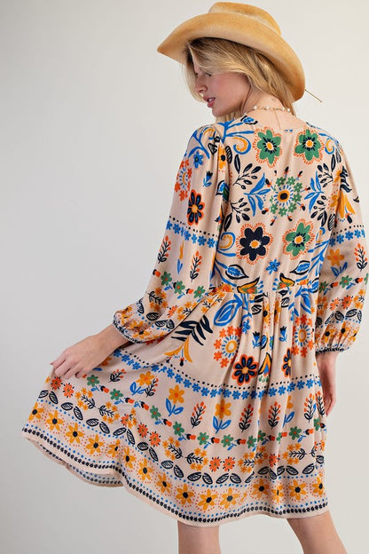 Woman wearing a colorful floral dress with a plain background
