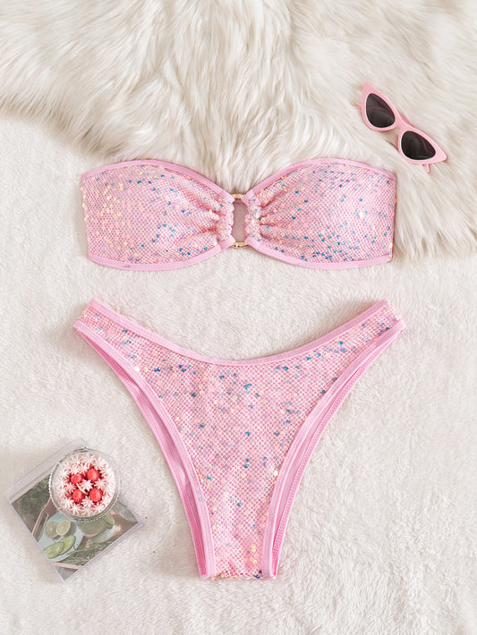 Pink bikini set with sunglasses and a magazine on a fluffy white surface