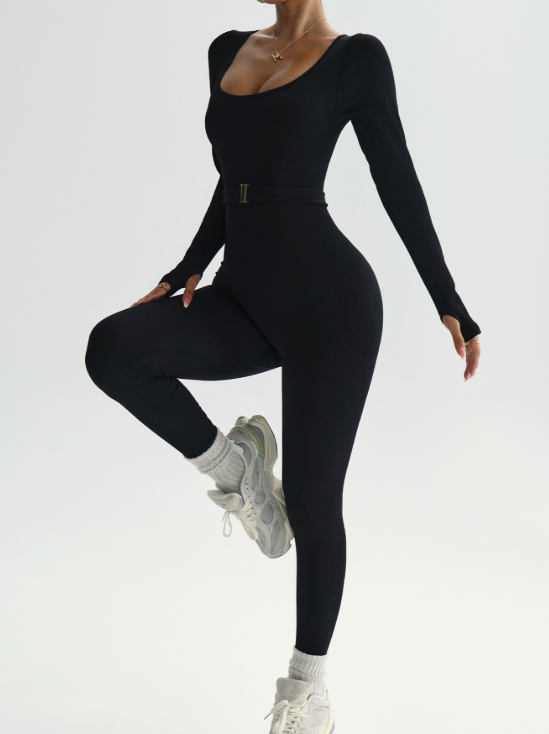 Person wearing a black long-sleeve top and leggings set on a white background