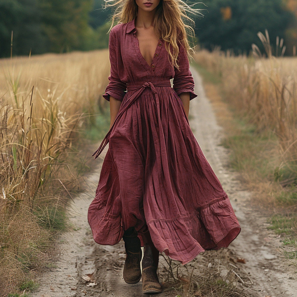 Woman in a long burgundy dress walking on a dirt path in a natural setting