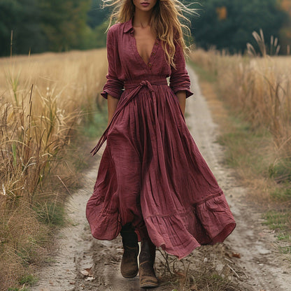 Woman in a long burgundy dress walking on a dirt path in a natural setting