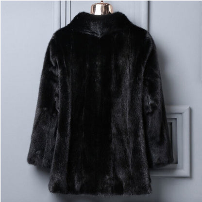 Black fur coat on a mannequin against a light gray wall.