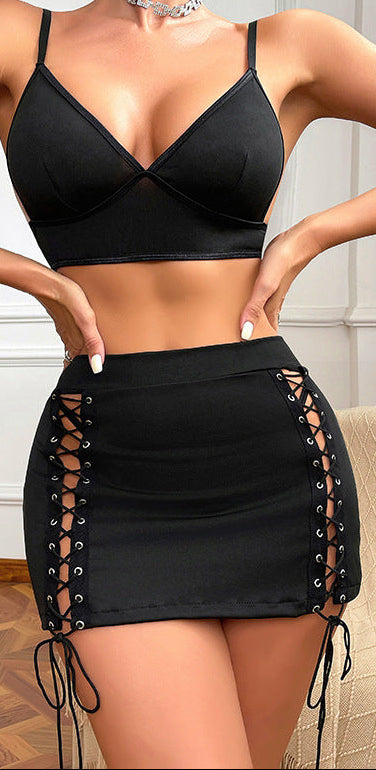 “Woman modelling slim-fit exposed-navel top and hip-hugging mini skirt lingerie set front view”
