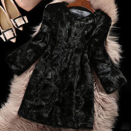 Black textured coat on a pink fur surface with shoes in the background