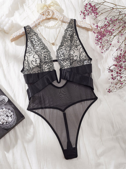 “detail close-up of hollow-cut embroidery mesh and suspender strap on lingerie jumpsuit”