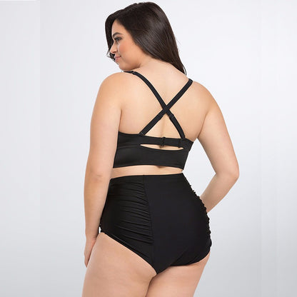 Woman wearing a black swimsuit with criss-cross back design on a white background